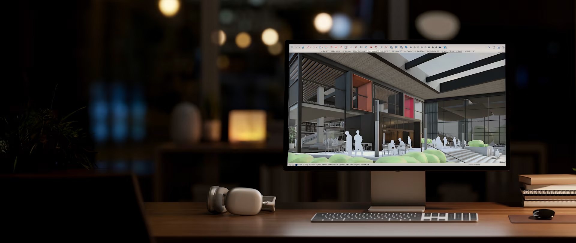 A SketchUp model of a modern multi-storey building open on a desktop monitor in a darkened studio